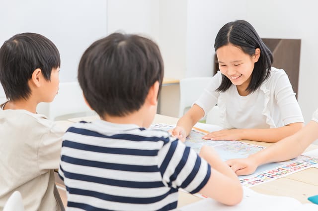 児童クラブで宿題をするこどもたちのようす